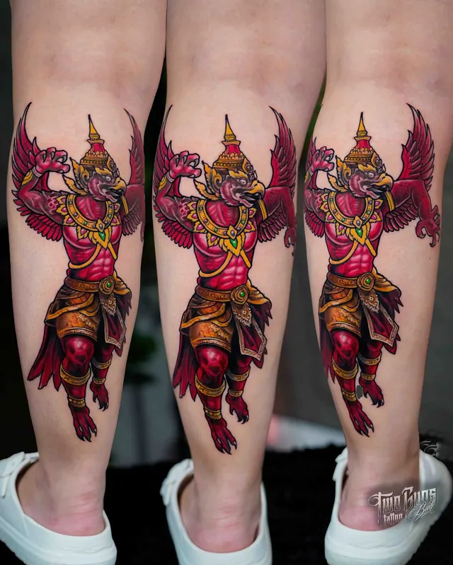 Colour Garuda calf tattoo in red and gold, the Balinese Hindu bird deity with wings spread