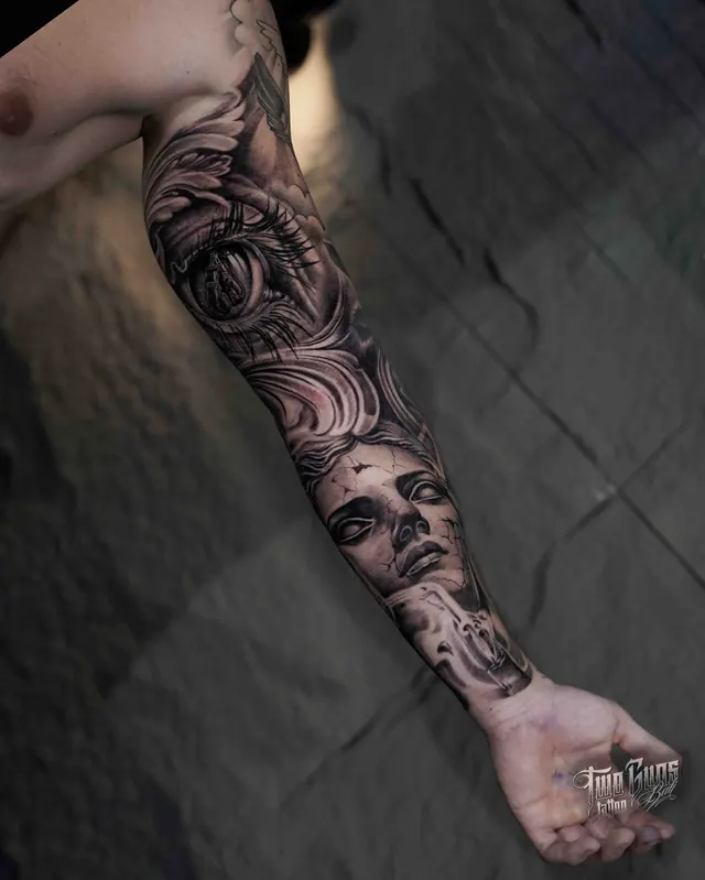 Black and grey full arm sleeve tattoo with ornamental work and a woman's face
