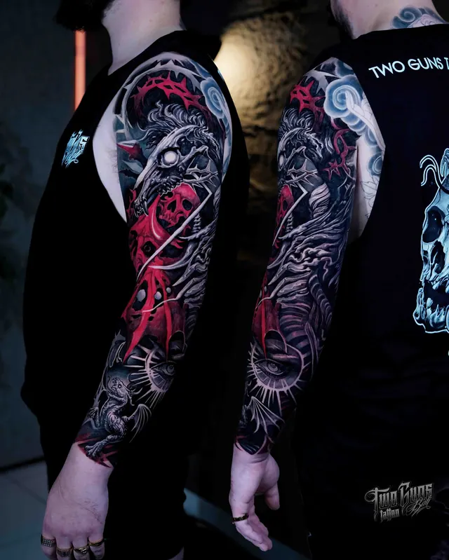Black and grey arm sleeve tattoos with red accents, a raven and roses