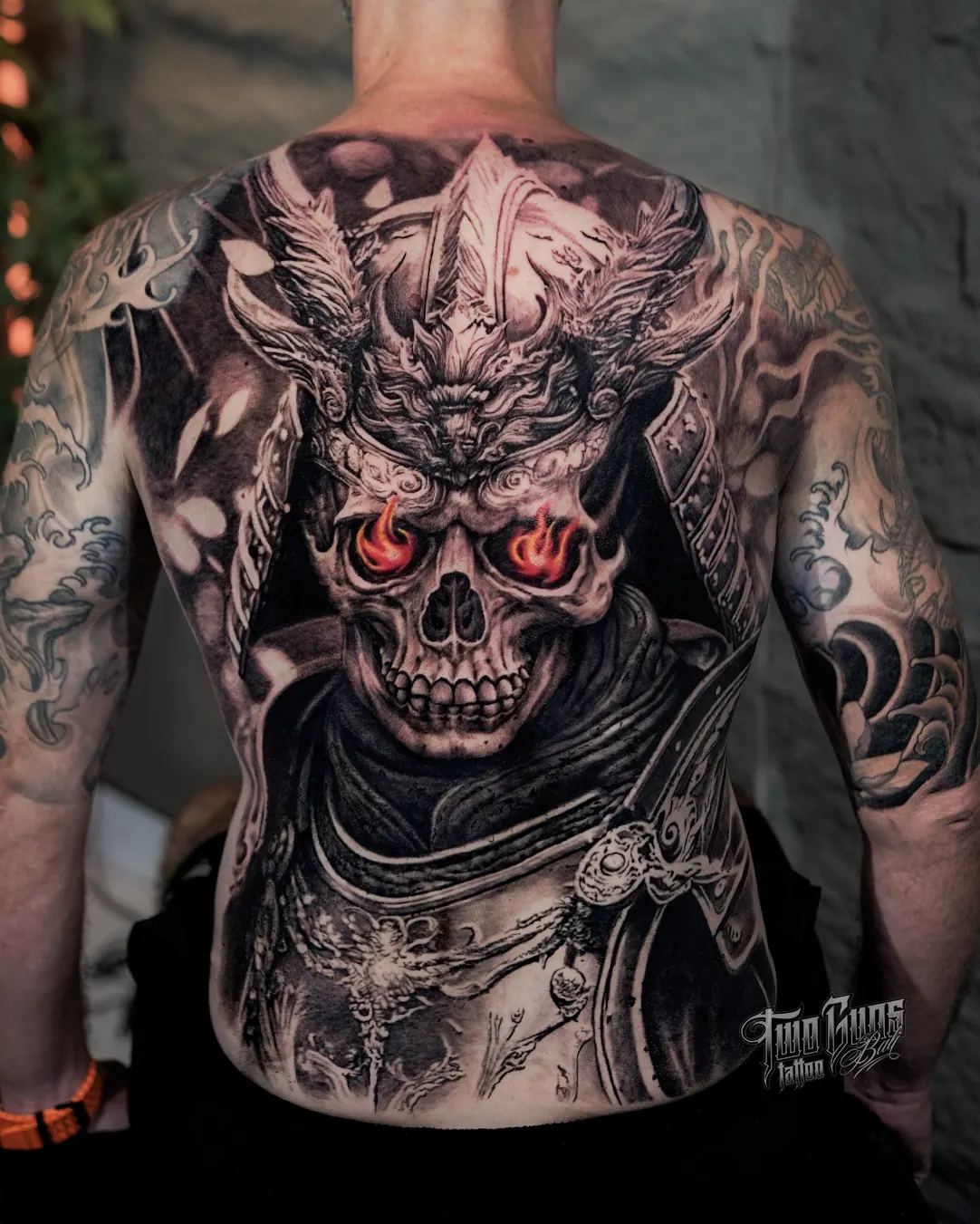 Black and grey full back tattoo of a horned skull warrior with red eyes
