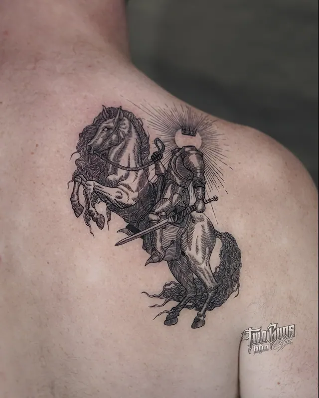 Fine line engraving-style tattoo of an armoured knight on a rearing horse, on a man's shoulder blade