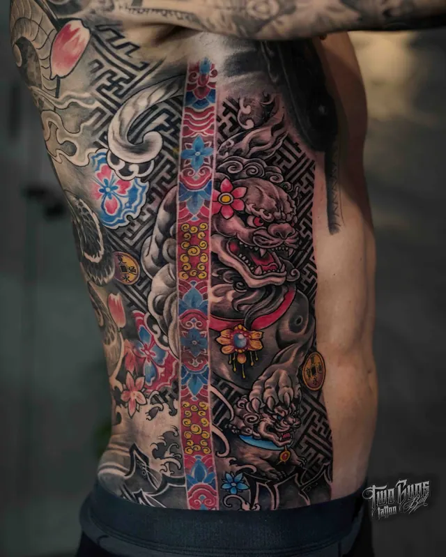 Traditional Japanese body suit tattoo across the ribs and back, shown from the side