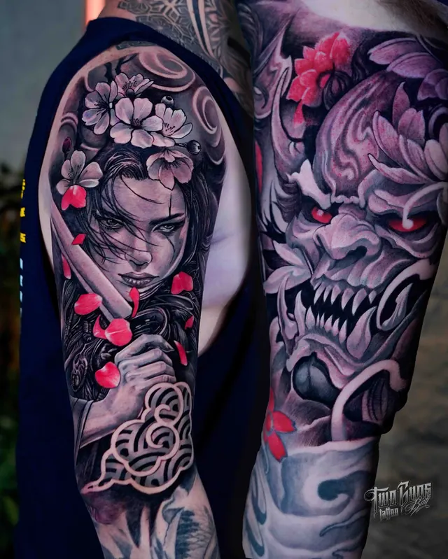 Neo-Japanese upper arm tattoo of a geisha with cherry blossoms and a fanged oni mask