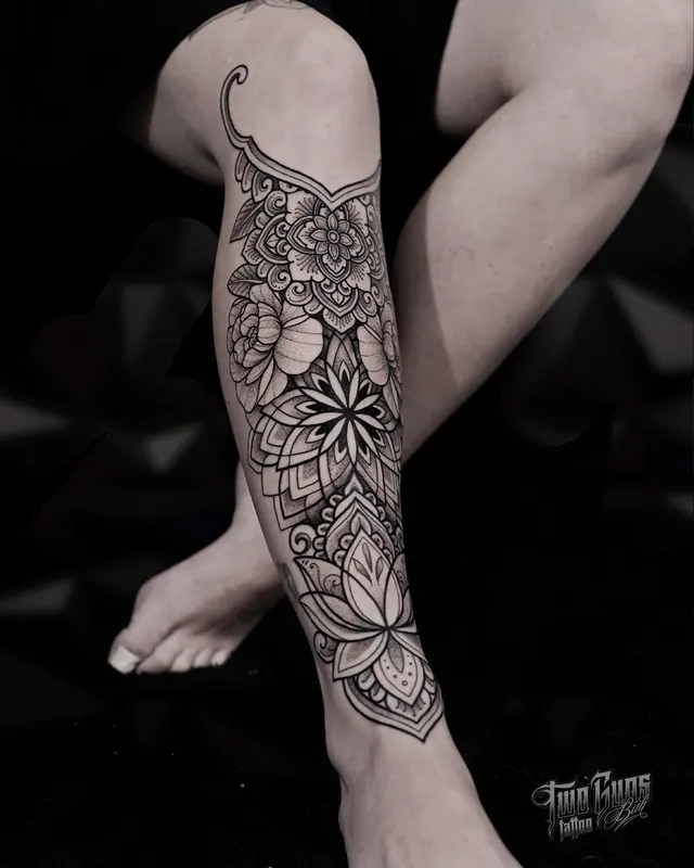Fine line mandala and flower tattoo wrapping the lower leg