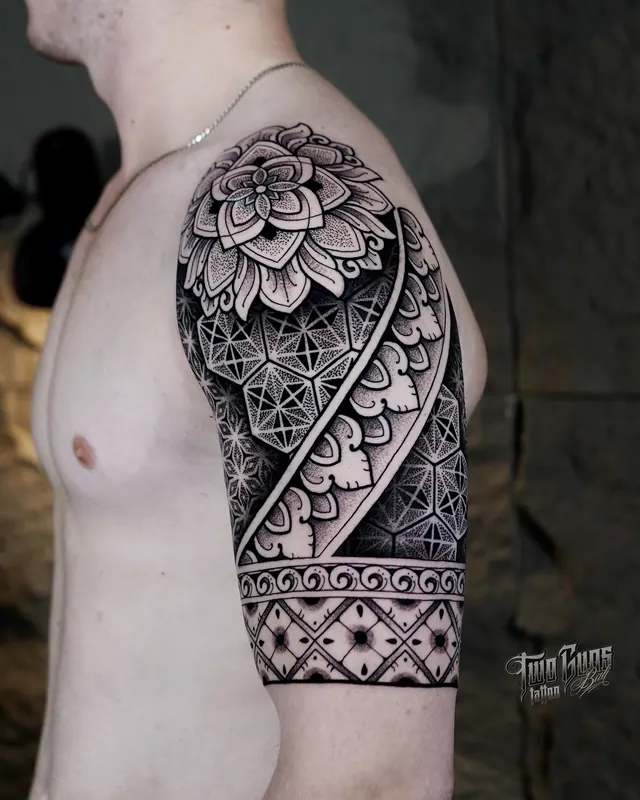Dotwork mandala half sleeve tattoo with a solid black band on the upper arm