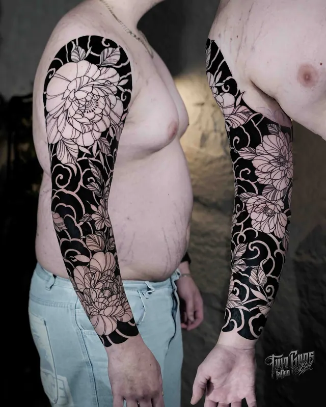 Blackwork full sleeve tattoo of large negative space peonies, two angles