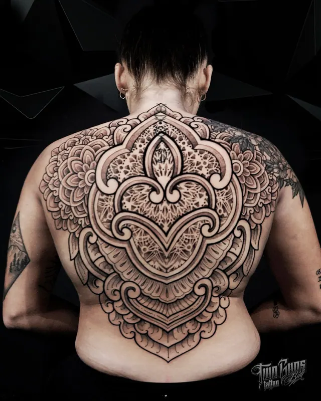 Ornamental mandala and filigree full back tattoo on a woman
