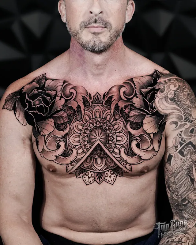 Large ornamental mandala chest panel tattoo across the chest and shoulders