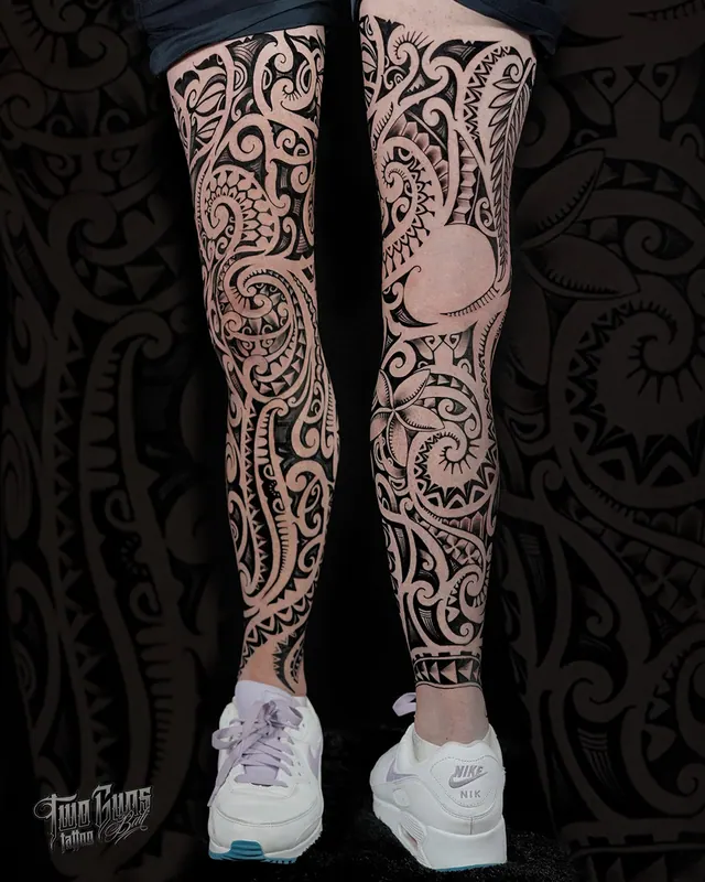 Maori style full leg tattoos in black, shown from two angles