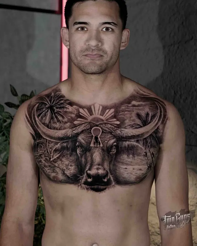 Black and grey realism chest tattoo of a Balinese bull with temple and landscape detail