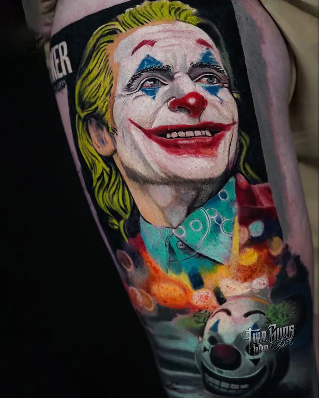 Colour realism upper arm tattoo of the Joker with a clown money box
