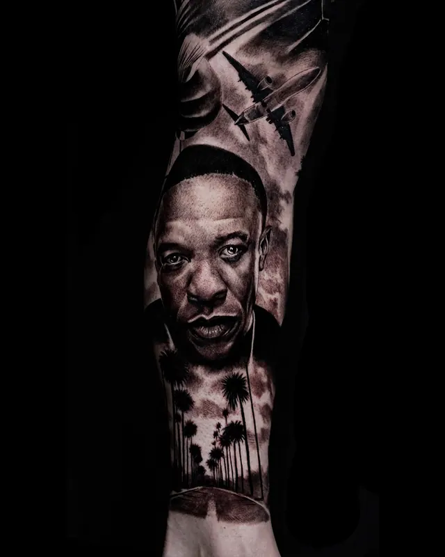 Black and grey realism leg sleeve tattoo of hip hop portraits, shown from the side