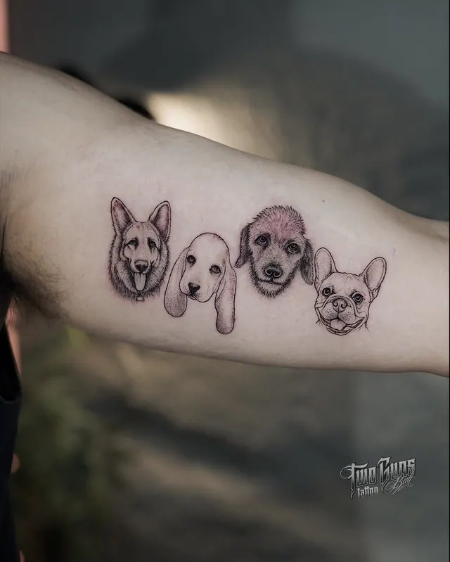 Four small dog portrait tattoos in a row along the inner arm