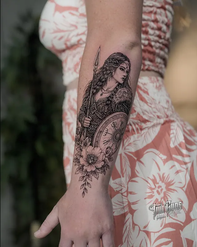 Fine line forearm tattoo of a woman warrior with ornamental flowers and a compass