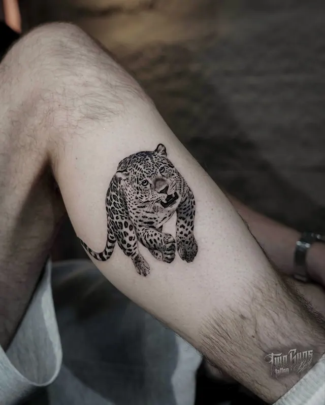 Fine line leopard tattoo on the upper arm