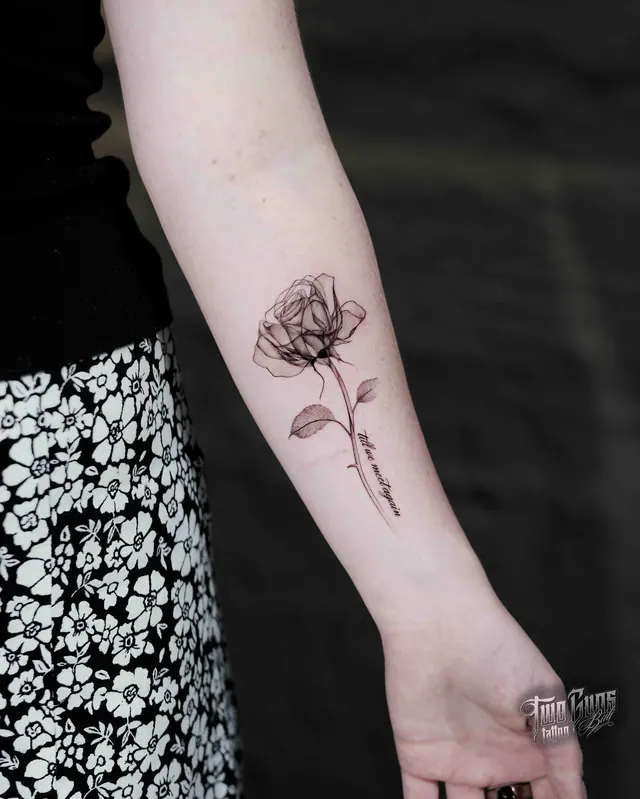 Fine line rose tattoo on a woman's forearm