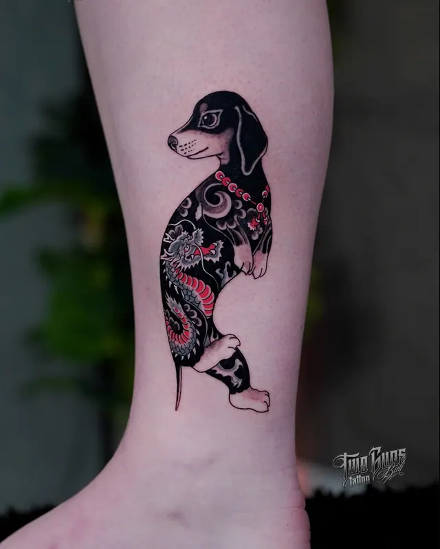 Black and red tattoo of a dachshund with Japanese ornamental fill, on the ankle