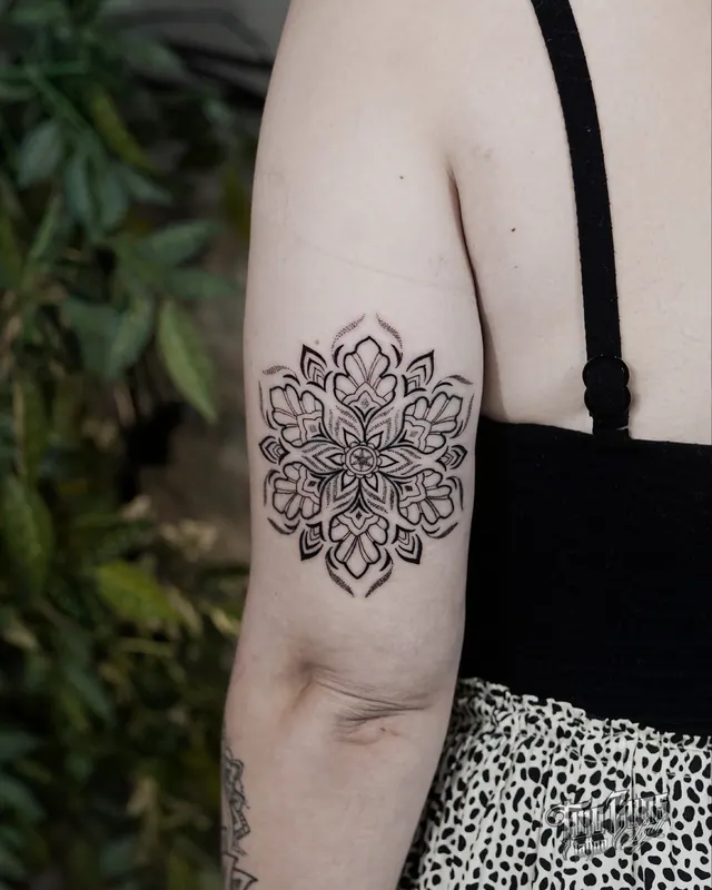 Dotwork mandala tattoo on a woman's upper arm