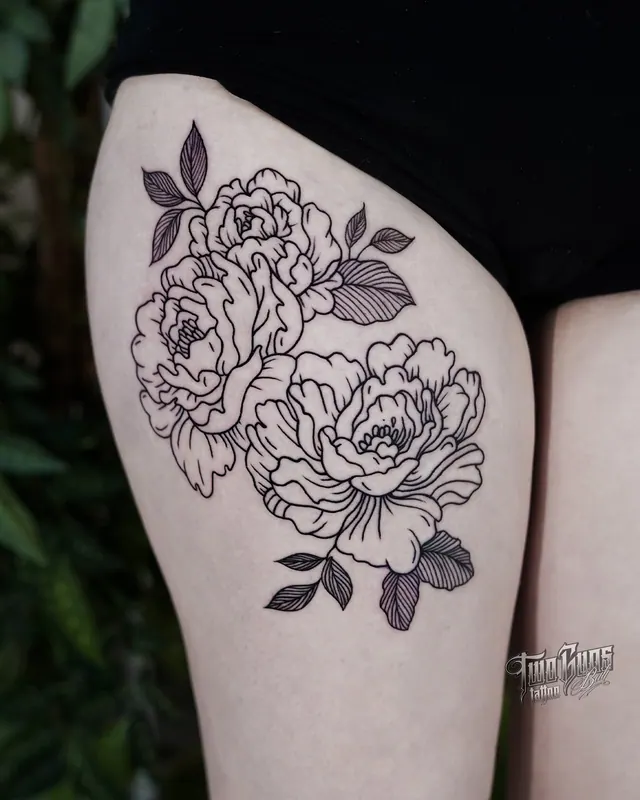 Fine line peony tattoo on a woman's thigh in clean black linework