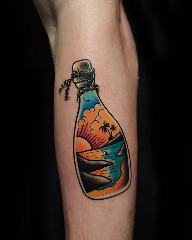 Colour traditional upper arm tattoo of a ship in a bottle at sunset