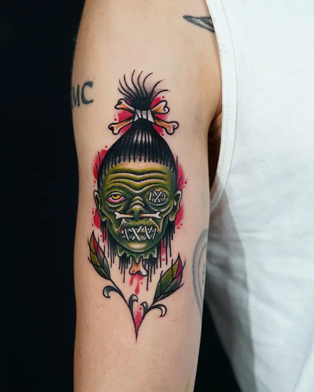 Colour neo-traditional upper arm tattoo of a shrunken head with pink flowers